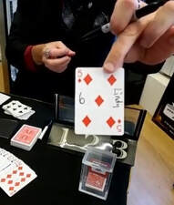 Close-up magic show magician Matthew King displaying a signed playing card in San Diego.