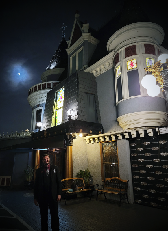 Magician Matthew King standing in front of the Magic Castle with full moon in sky.