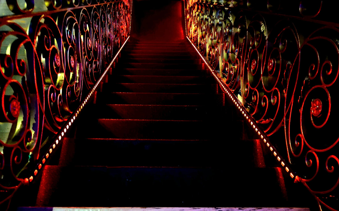 Red and Black decorative staircase at The Tipsy Crow where San Diego Magician Matthew King performs