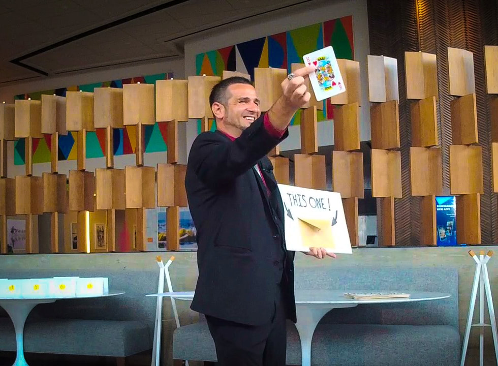 San Diego magician Matthew King performing parlor magic holding up a jumbo playing card for the audience to see